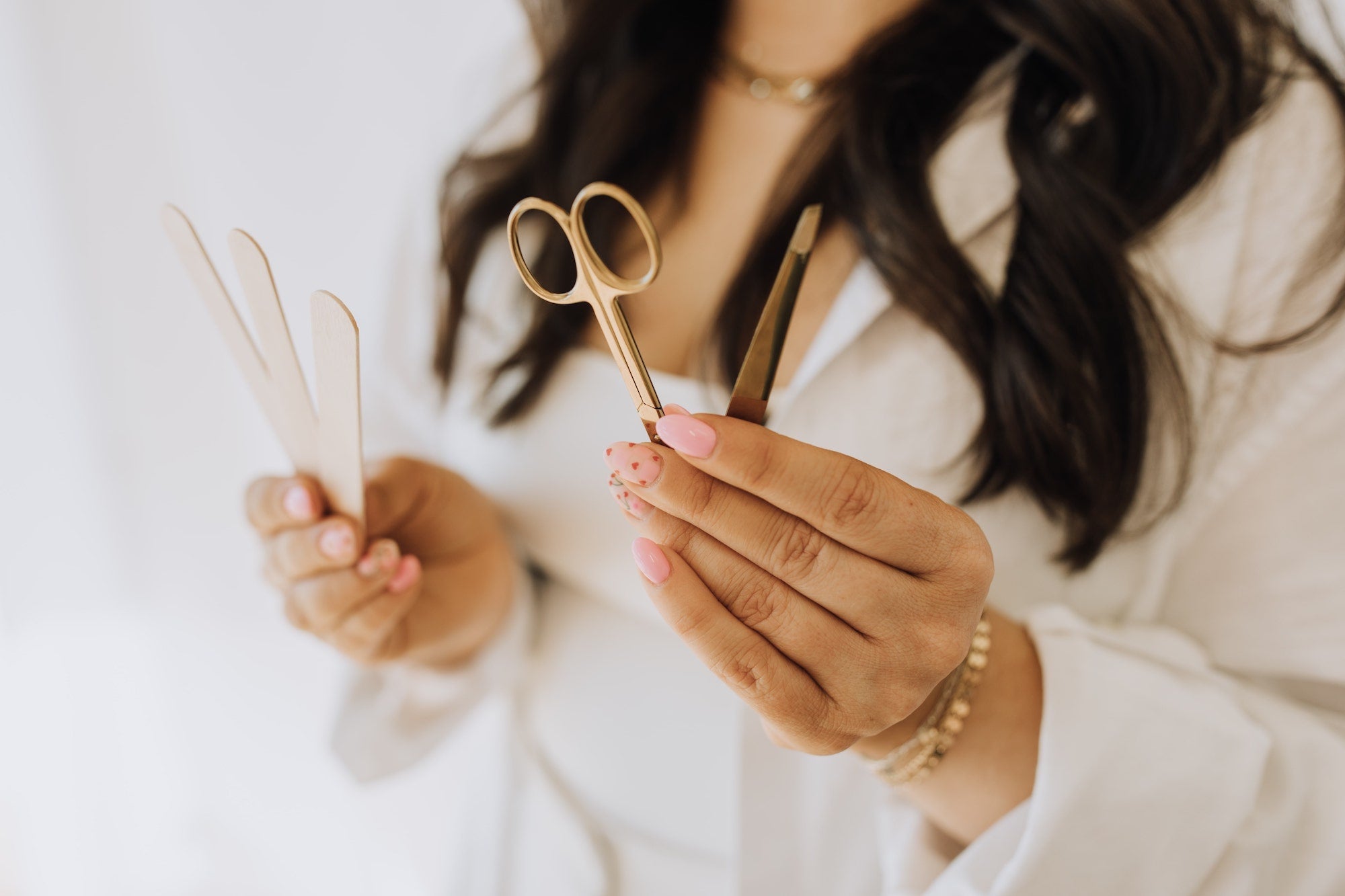 esthetician holding wax sticks and scissors, full body waxing in Phoenix